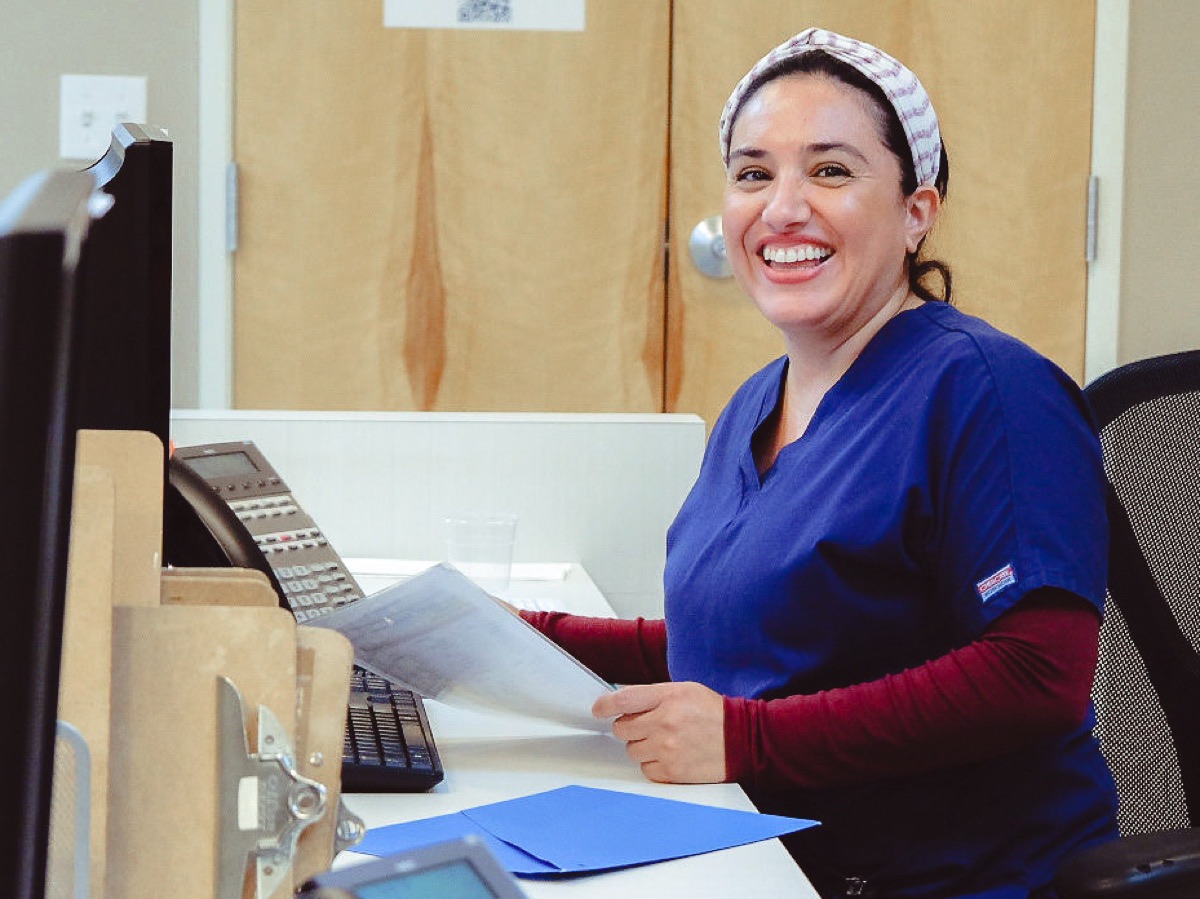 A staff member smiling at the front desk