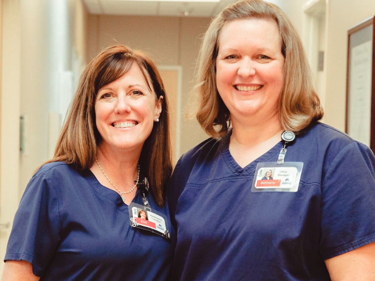 Two members of our nursing staff smiling in the hallway